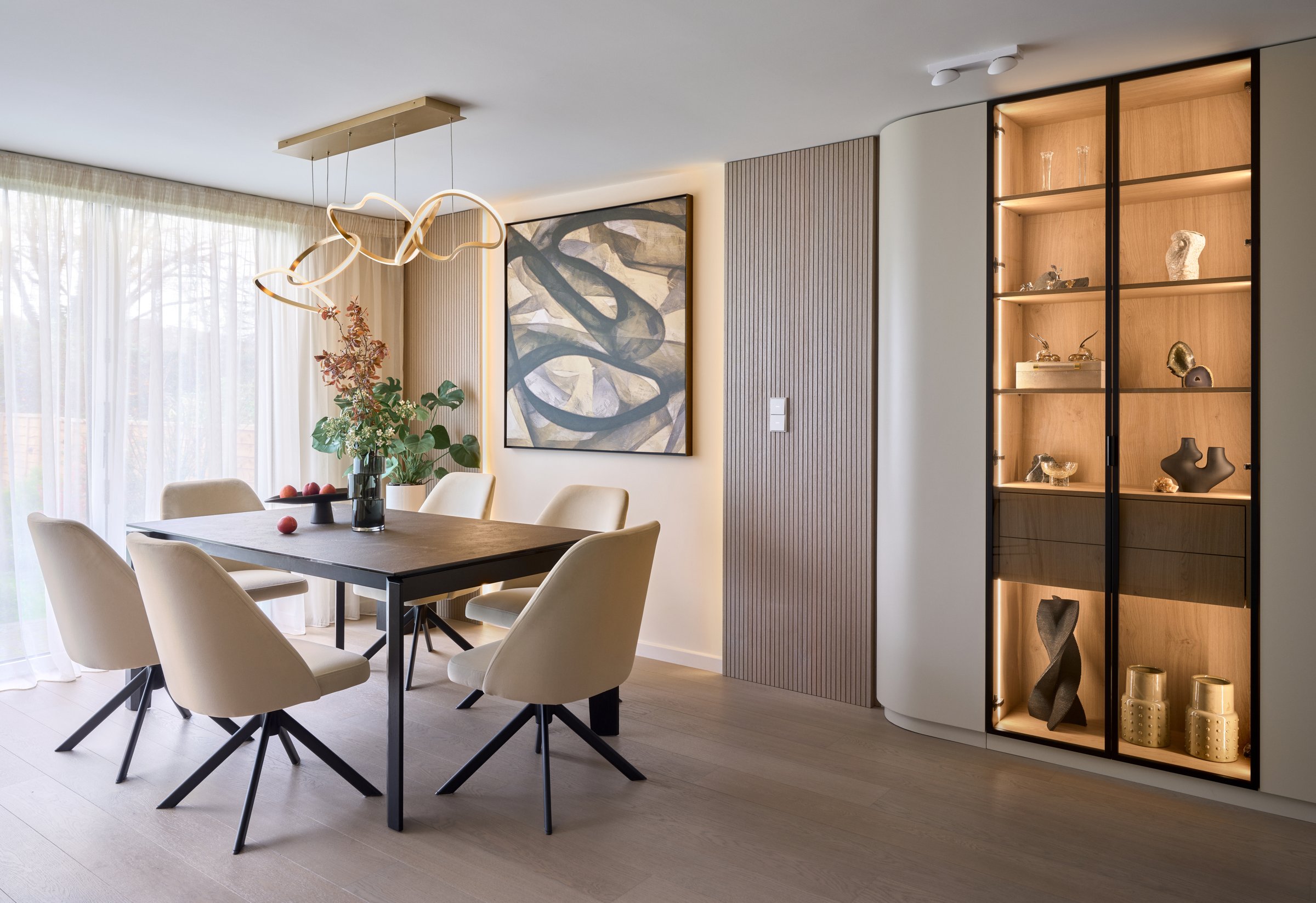 Contemporary dining room with fluted wall panelling and glass display cabinet, interior design by Studio 32